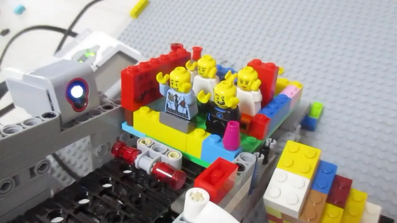 キャタピラの上に置かれているレゴのゴンドラに、レゴのフィギュアが乗っている。横にはカラーセンサが配置されている。