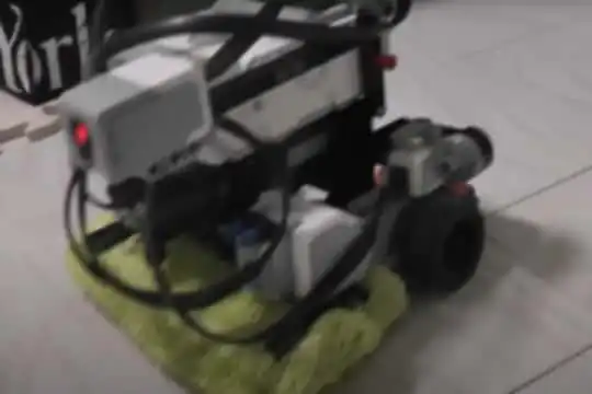 EV3で作ったロボット掃除機。前方に赤外線センサー、後方に可視光センサー、家庭用モップが取り付けてある。左右にモーターを搭載している。
