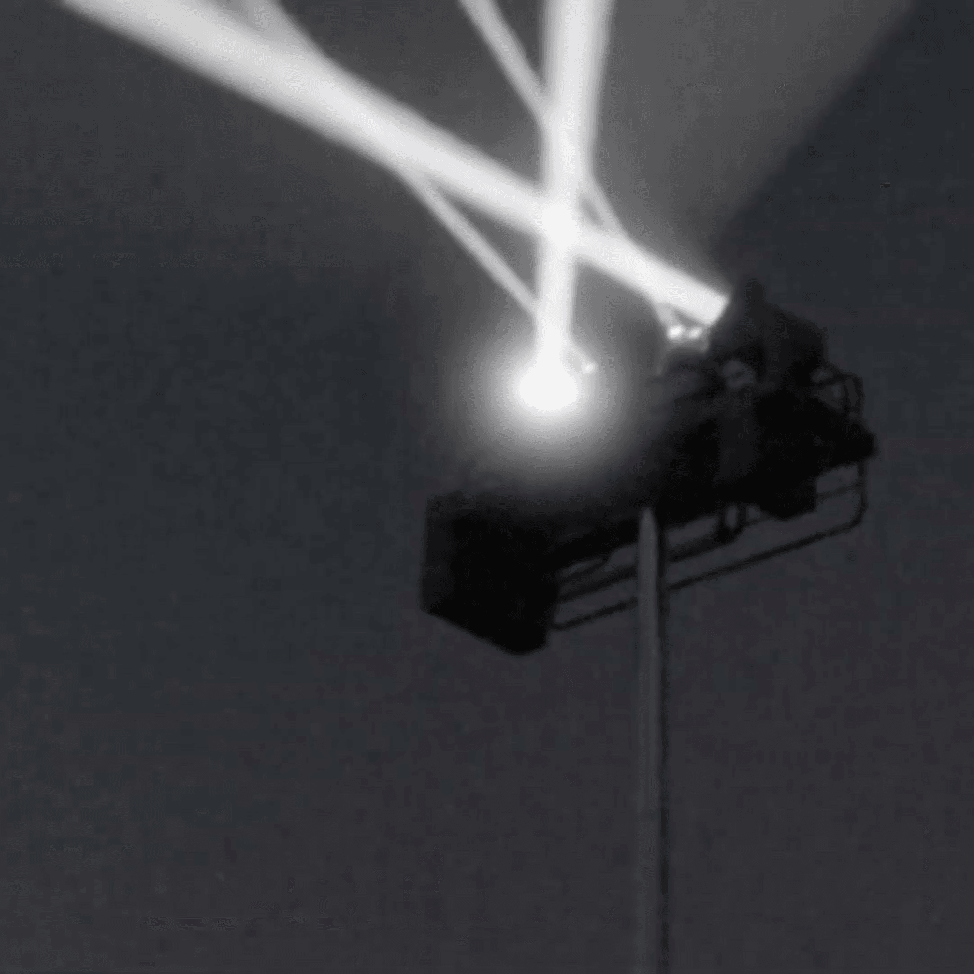 サーチライトが、4本の白い光を放っている。それぞれの光が空中で互いにクロスしている。